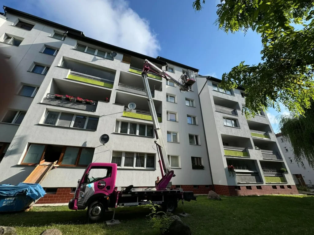 podnośnik koszowy przy dużym budynku mieszkalnym